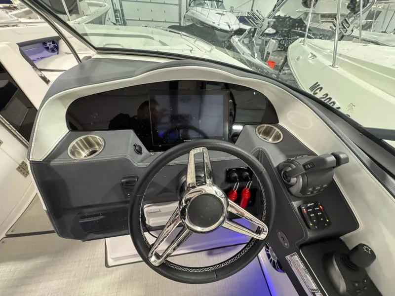 Slide: The Image of 2023 Regal 3300 boat dashboard with steering wheel and control panel. - 10
