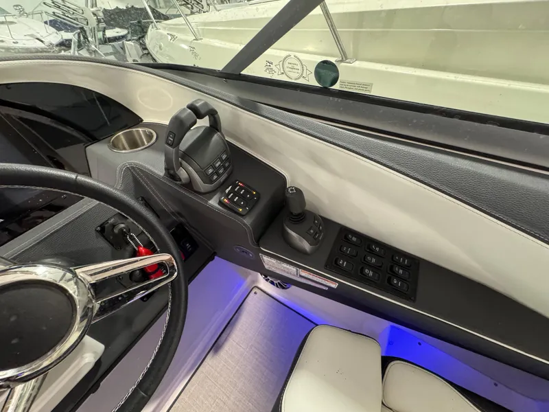 Slide: The Image of 2023 Regal 3300 boat helm with steering wheel, controls, and switches in a modern cockpit. - 11