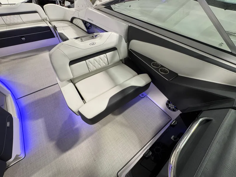 Slide: The Image of 2023 Regal 3300 boat interior with luxurious seating and ambient blue lighting. - 12