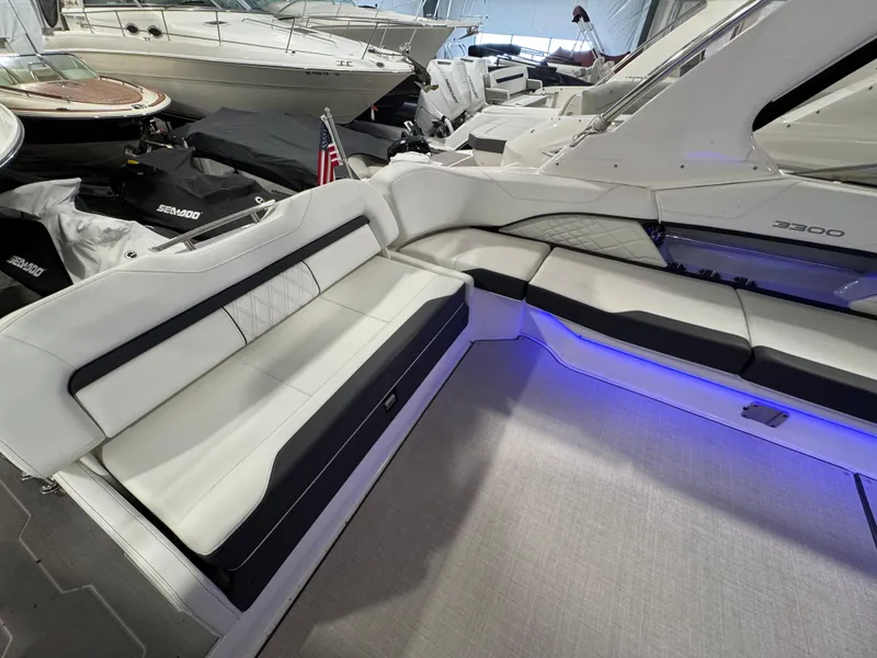 Slide: The Image of 2023 Regal 3300 boat interior with white seating and blue LED lighting. - 3