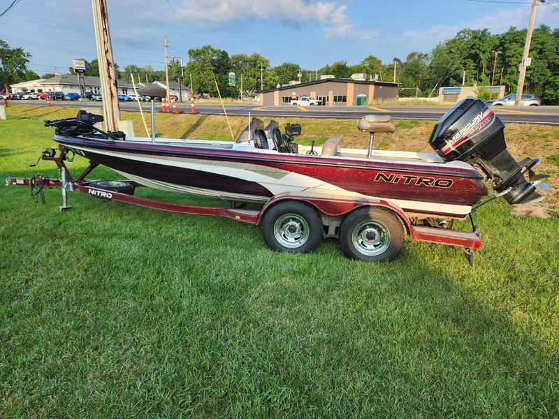 Slide: The Image of 2001 Nitro 896 DC boat on trailer, parked on grass, with outboard motor. - 3
