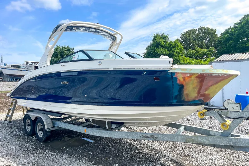 Slide: The Image of 2019 Sea Ray 270 Sundeck SDX boat on trailer, parked outdoors. - 1