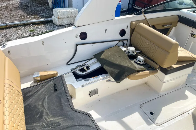 Slide: The Image of 2019 Sea Ray 270 Sundeck SDX interior with tan seating and storage compartments. - 11