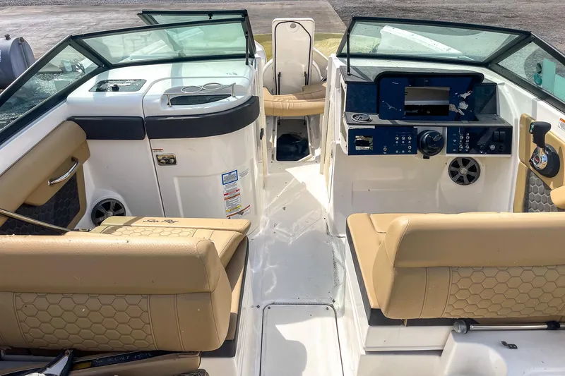 Slide: The Image of 2019 Sea Ray 270 Sundeck SDX interior with tan seating and modern dashboard. - 12