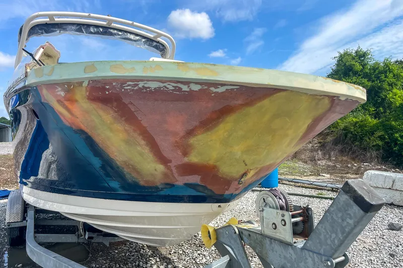 Slide: The Image of 2019 Sea Ray 270 Sundeck SDX on trailer, showing hull repair work under blue sky. - 22