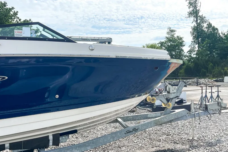 Slide: The Image of 2019 Sea Ray 270 Sundeck SDX boat on trailer, blue hull, outdoor setting. - 29