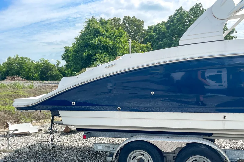 Slide: The Image of 2019 Sea Ray 270 Sundeck SDX boat on trailer, parked outdoors. - 30