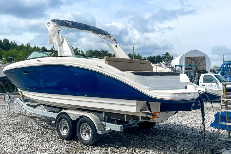 Slide: The Image of 2019 Sea Ray 270 Sundeck SDX boat on trailer, blue hull, outdoor setting. - 4