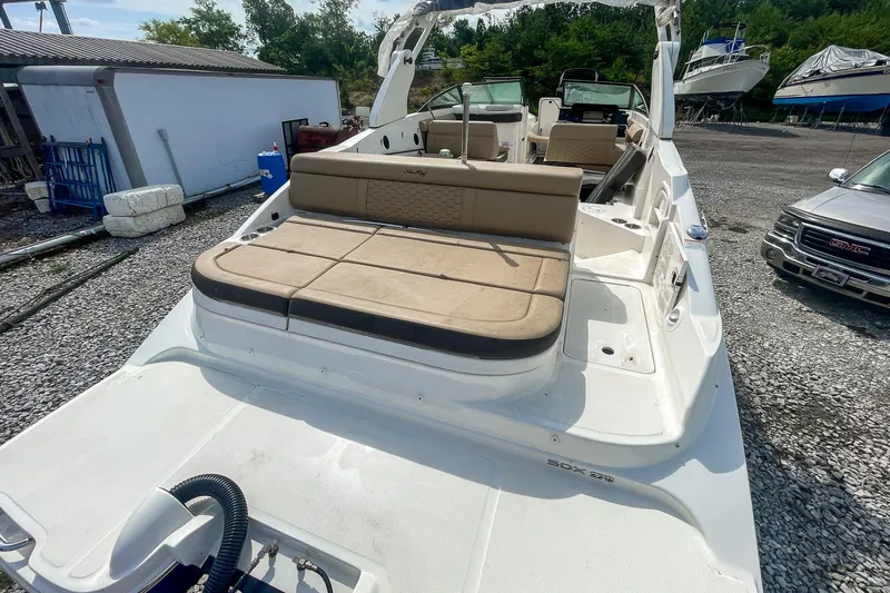 Slide: The Image of 2019 Sea Ray 270 Sundeck SDX boat with spacious seating, parked on gravel. - 7