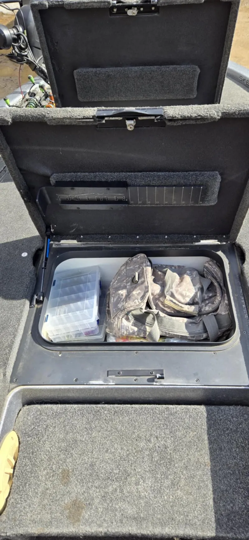 Slide: The Image of 2013 Skeeter ZX20 storage compartment with fishing gear and tackle box. - 17