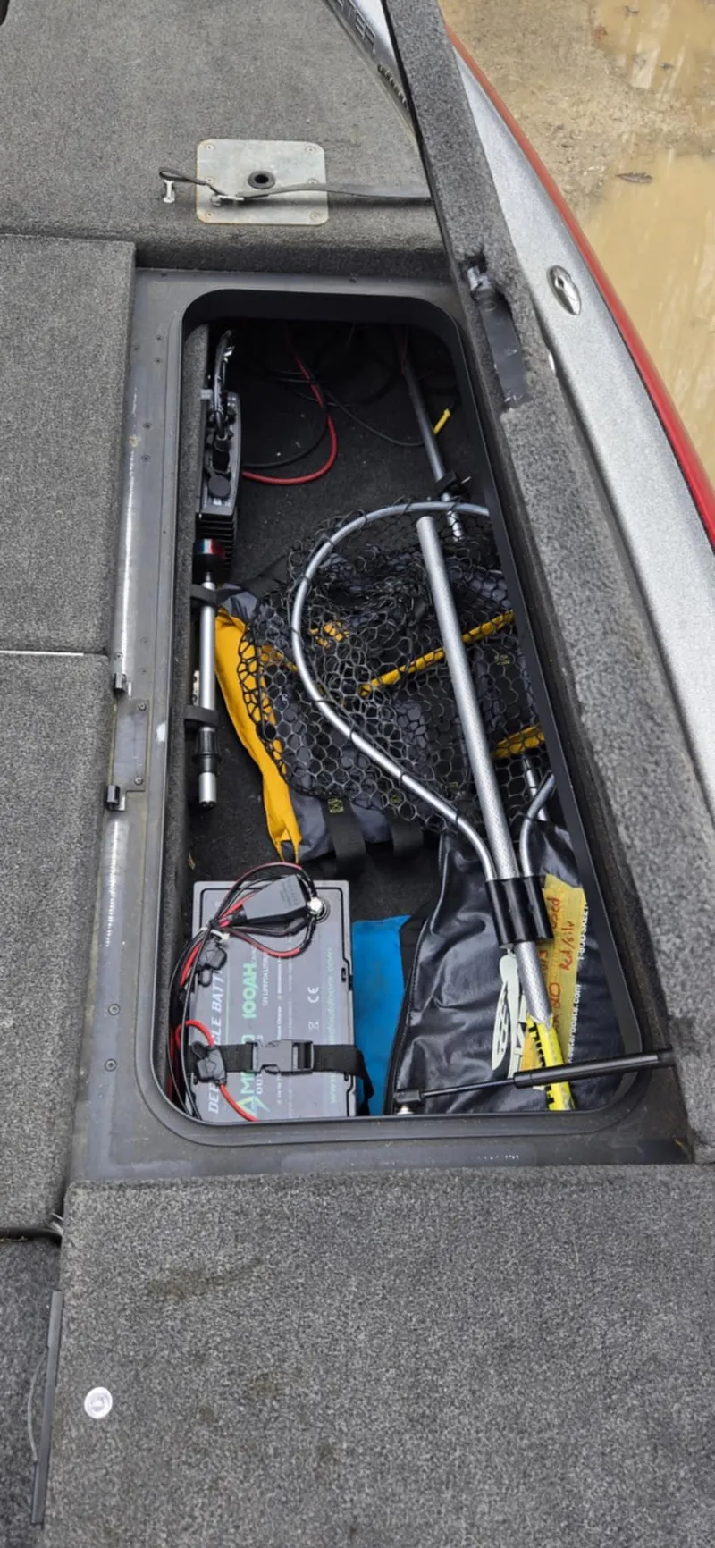 Slide: The Image of 2013 Skeeter ZX20 boat storage compartment with fishing gear and battery. - 21