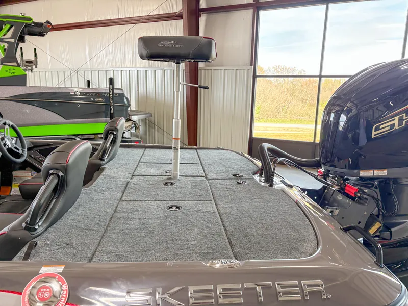 Slide: The Image of 2025 Skeeter ZXR 19 boat interior with seating and motor, in a showroom setting. - 3
