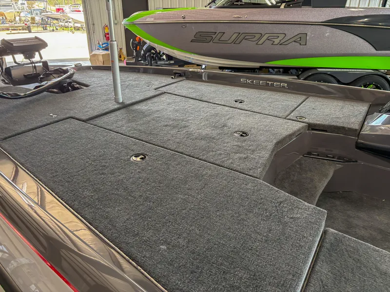 Slide: The Image of 2025 Skeeter ZXR 19 boat interior with carpeted deck and storage compartments. - 6