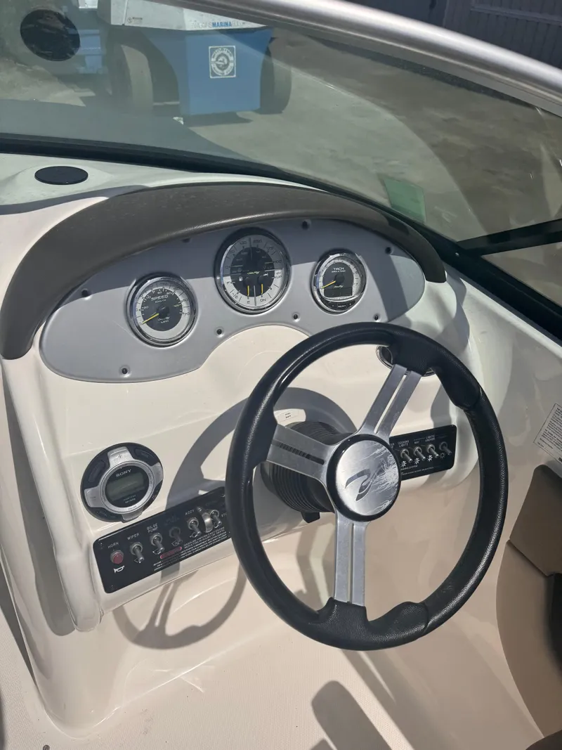 Slide: The Image of Steering console of a 2012 Sea Ray 200 SD boat with gauges and controls. - 2