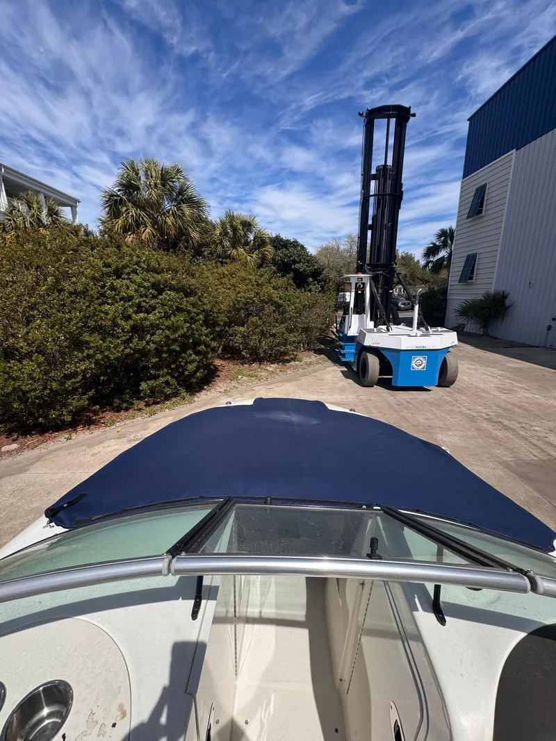 Slide: The Image of 2012 Sea Ray 200 SD boat with forklift in marina setting, under blue sky. - 8