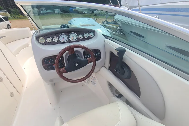 Slide: The Image of 2005 Chaparral 264 Sunesta boat dashboard with gauges and wooden steering wheel. - 12