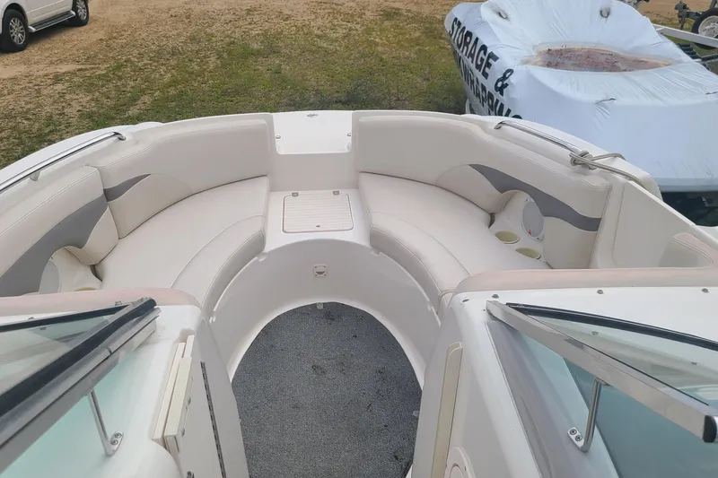 Slide: The Image of 2005 Chaparral 264 Sunesta boat interior with white seating and storage compartments. - 15