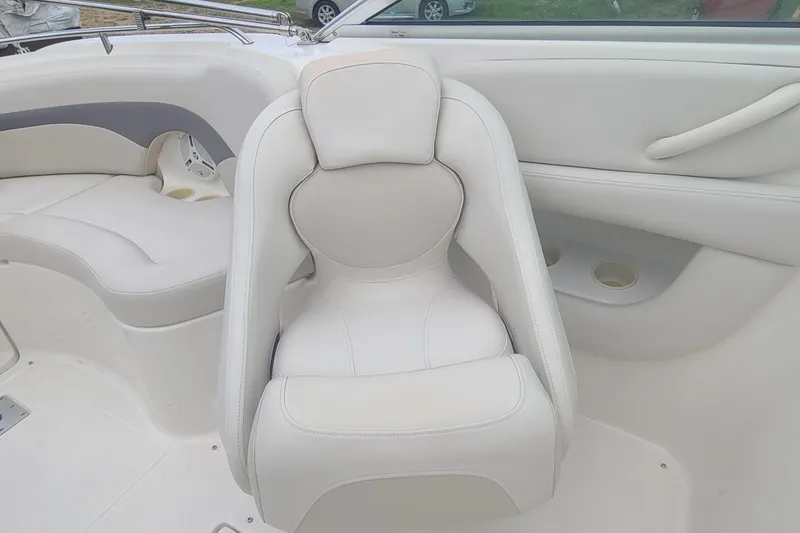 Slide: The Image of 2005 Chaparral 264 Sunesta boat interior with white seating and cup holders. - 7