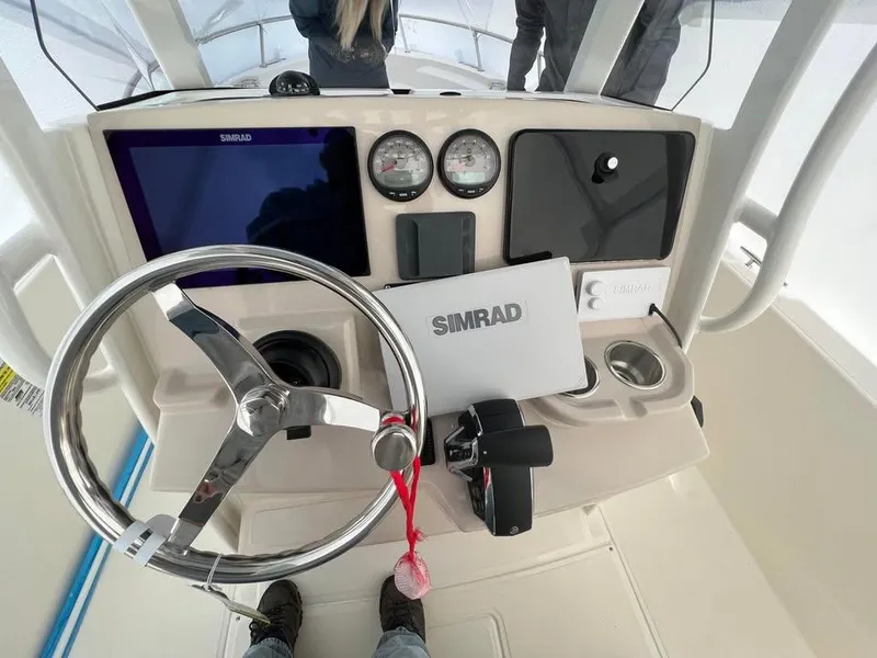 Slide: The Image of 2023 Boston Whaler 220 Dauntless helm with Simrad electronics and modern steering wheel. - 2