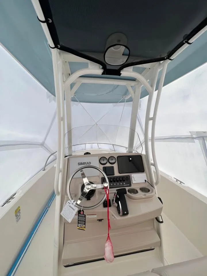 Slide: The Image of 2023 Boston Whaler 220 Dauntless boat console with steering wheel and navigation equipment. - 3