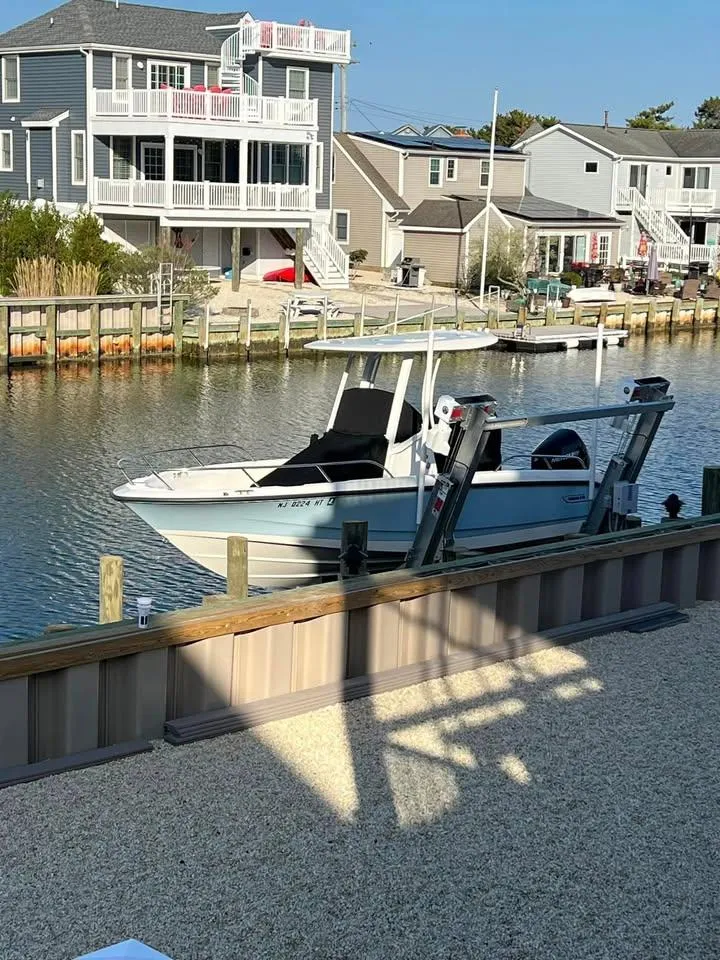 Slide: The Image of 2023 Boston Whaler 220 Dauntless boat docked in a residential canal setting. - 4