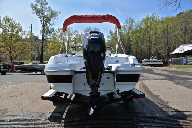 Slide: The Image of 2018 Tahoe 550 TS boat with outboard motor, parked on a ramp, surrounded by trees. - 13
