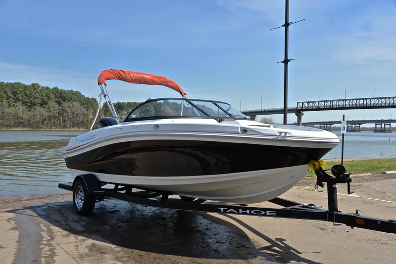 Slide: The Image of 2018 Tahoe 550 TS boat on trailer by a river, under a clear sky. - 16