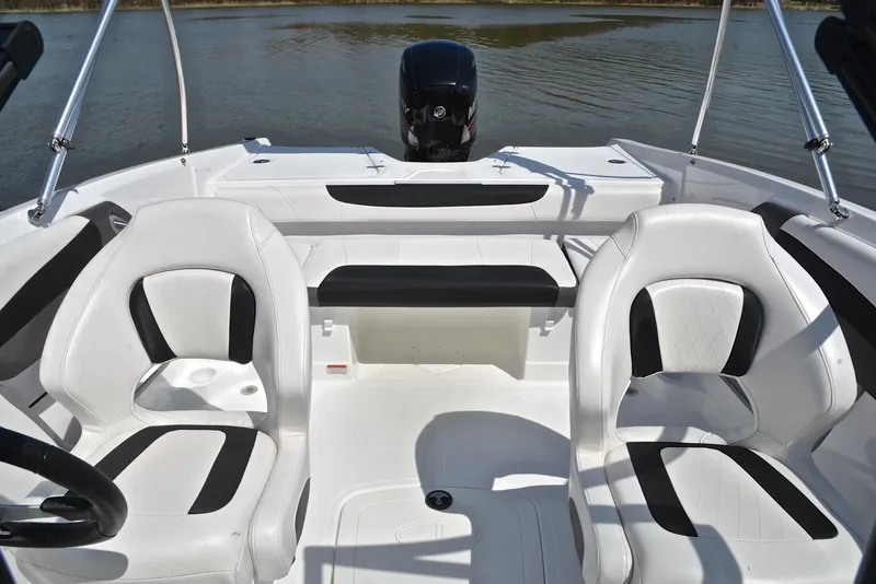Slide: The Image of 2018 Tahoe 550 TS boat interior with white and black seating on calm water. - 22