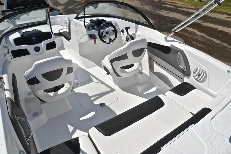 Slide: The Image of 2018 Tahoe 550 TS boat interior with white and black seating, steering wheel, and dashboard. - 23