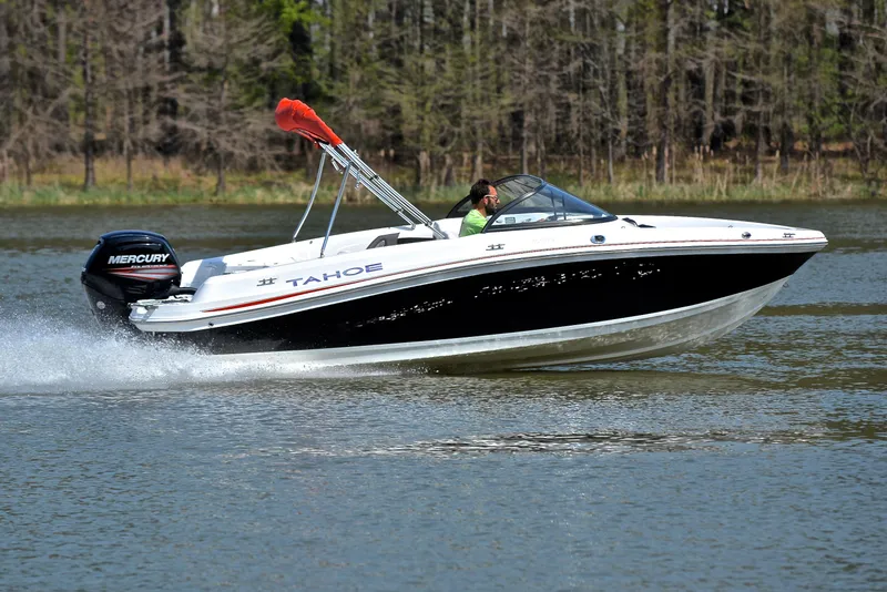 Slide: The Image of 2018 Tahoe 550 TS speedboat cruising on a lake with forested background. - 3