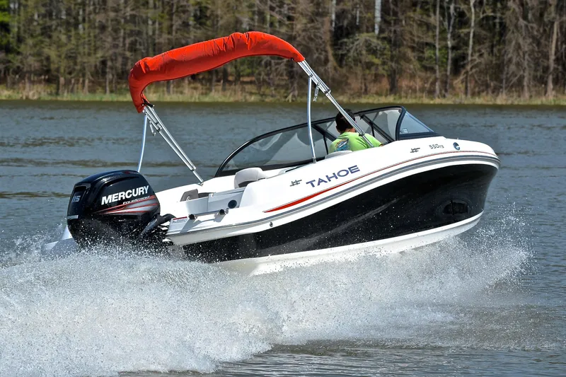 Slide: The Image of 2018 Tahoe 550 TS boat cruising on a lake with a Mercury engine. - 5