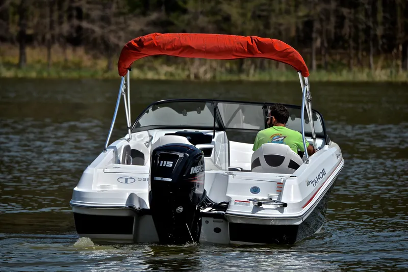 Slide: The Image of 2018 Tahoe 550 TS boat with red canopy on a lake. - 8