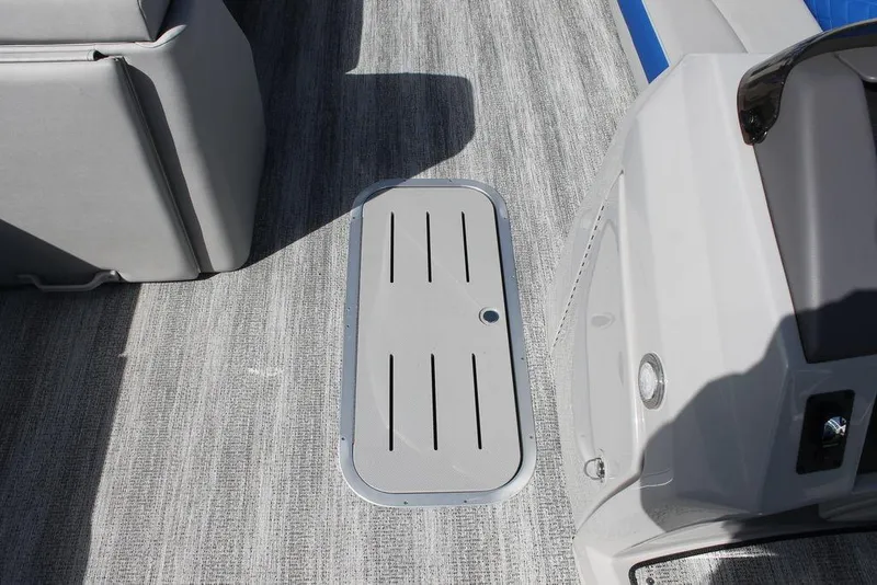Slide: The Image of 2025 Bennington L Quad Bench 25 LFB boat interior with gray flooring and storage compartment. - 12