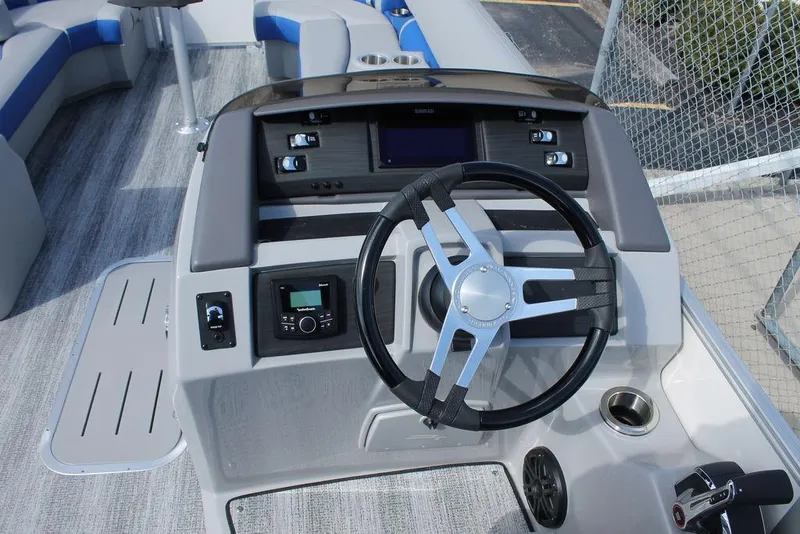 Slide: The Image of 2025 Bennington L Quad Bench 25 LFB boat dashboard with steering wheel and controls. - 9