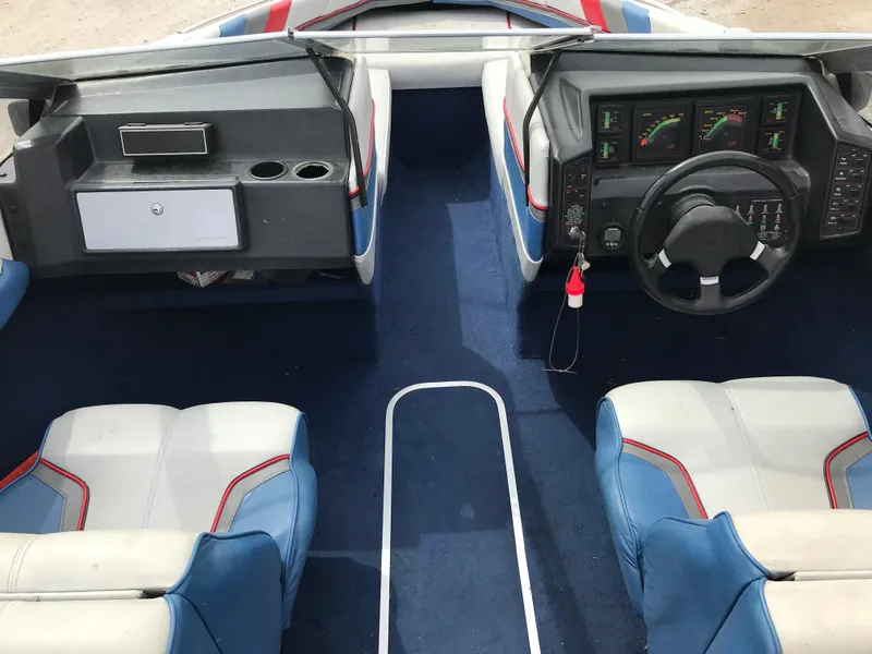 Slide: The Image of 1987 Bayliner 1950 Capri boat interior with blue carpet and white-blue seats. - 13