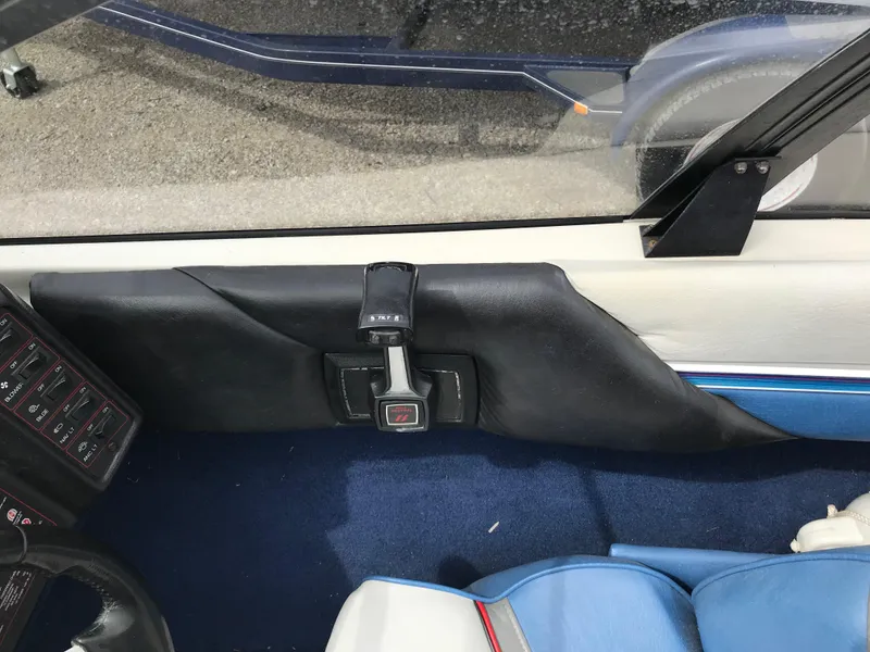 Slide: The Image of Interior of a 1987 Bayliner 1950 Capri boat, featuring blue and white seating. - 22