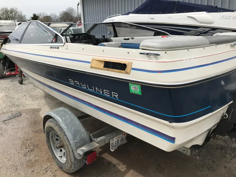 Slide: The Image of 1987 Bayliner 1950 Capri boat on trailer, parked outdoors. - 25
