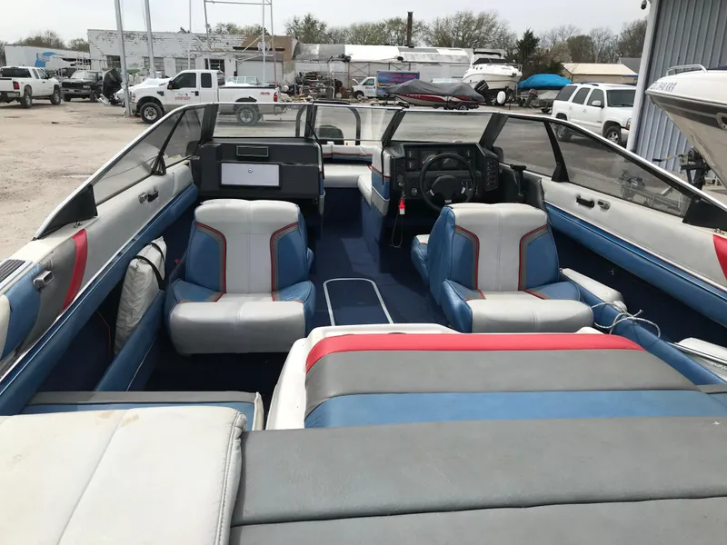 Slide: The Image of 1987 Bayliner 1950 Capri interior with blue and white seating, parked in a lot. - 26