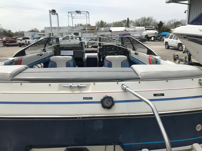 Slide: The Image of 1987 Bayliner 1950 Capri boat with open cockpit, parked in a marina. - 27