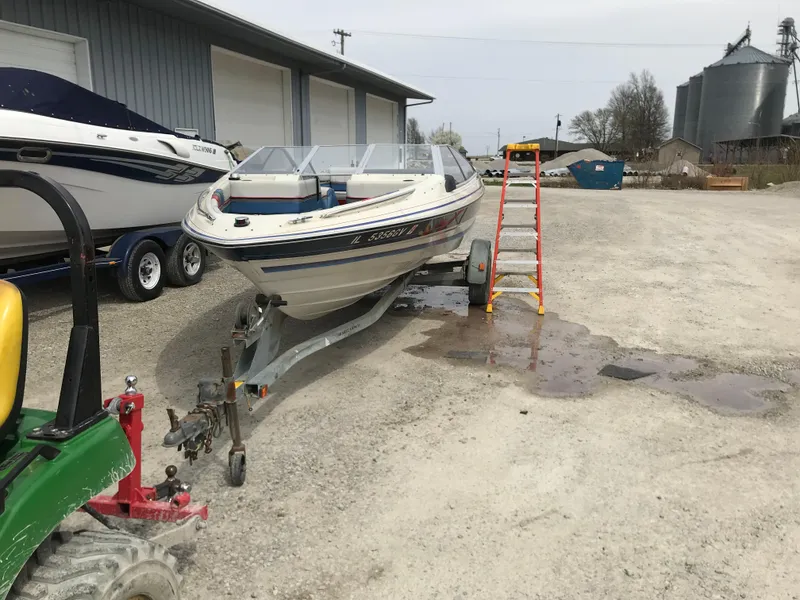 Slide: The Image of 1987 Bayliner 1950 Capri boat on trailer, parked outdoors near a building. - 3