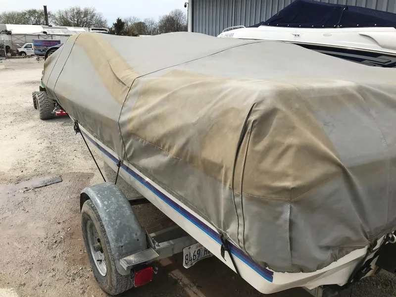Slide: The Image of Covered 1987 Bayliner 1950 Capri boat on trailer in outdoor storage area. - 30