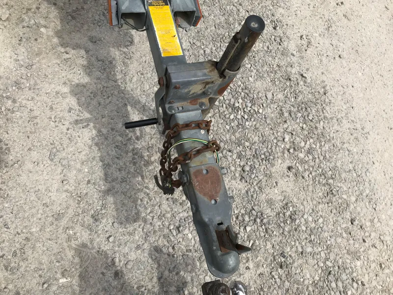 Slide: The Image of Trailer hitch of a 1987 Bayliner 1950 Capri on gravel surface. - 34