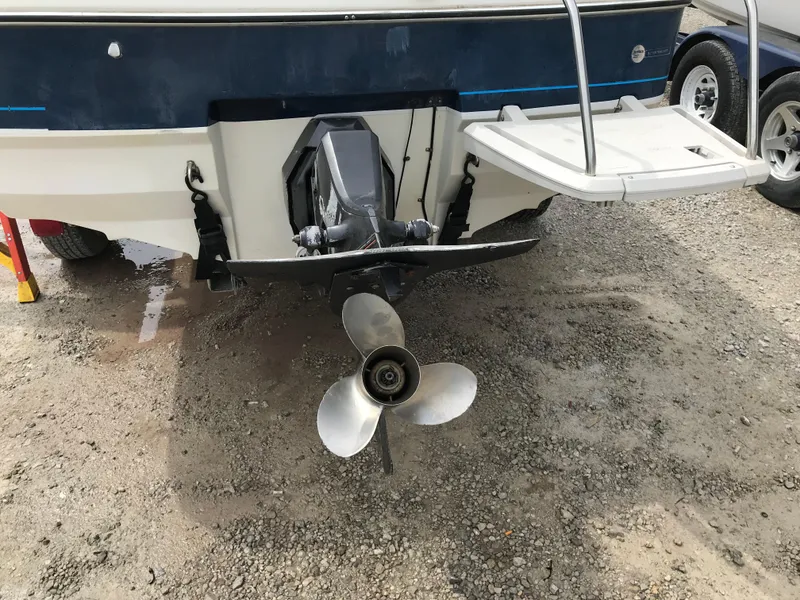 Slide: The Image of 1987 Bayliner 1950 Capri boat stern with propeller and swim platform on gravel. - 4