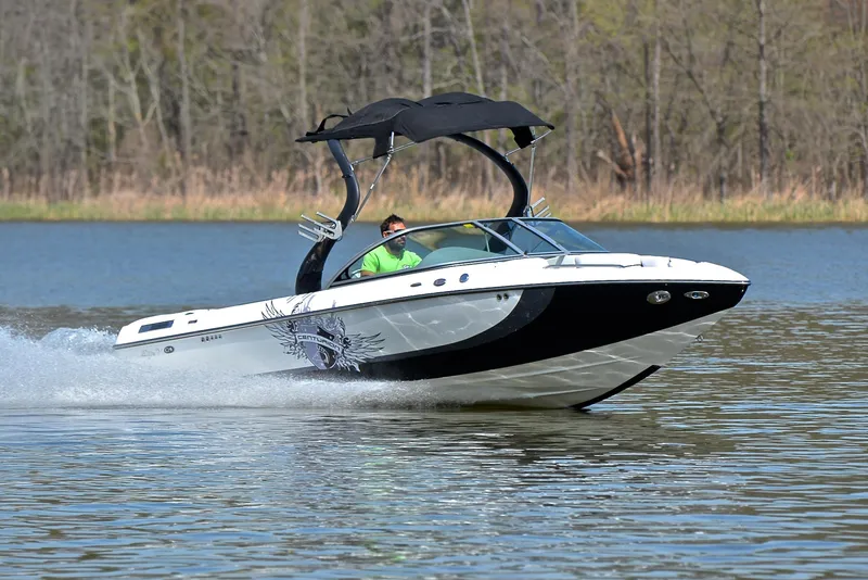 Slide: The Image of 2012 Centurion ELITE C4 boat cruising on a lake with a canopy. - 1