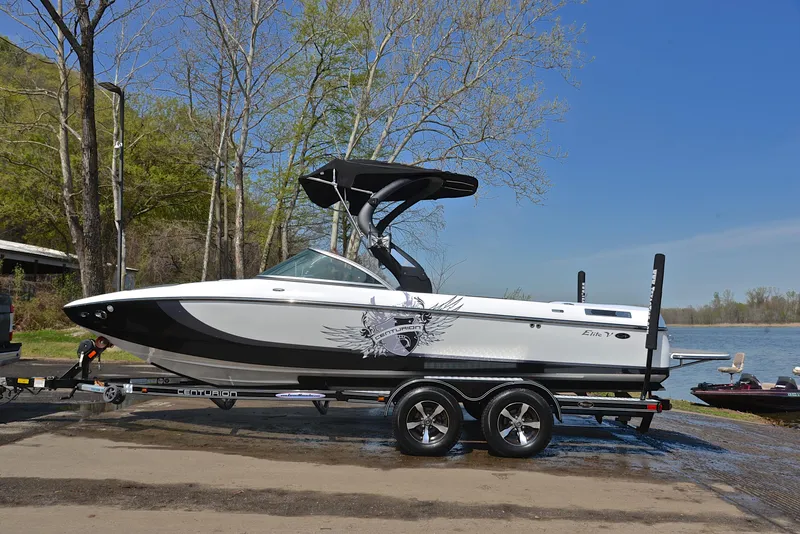 Slide: The Image of 2012 Centurion ELITE C4 boat on trailer by lakeside, under clear blue sky. - 11