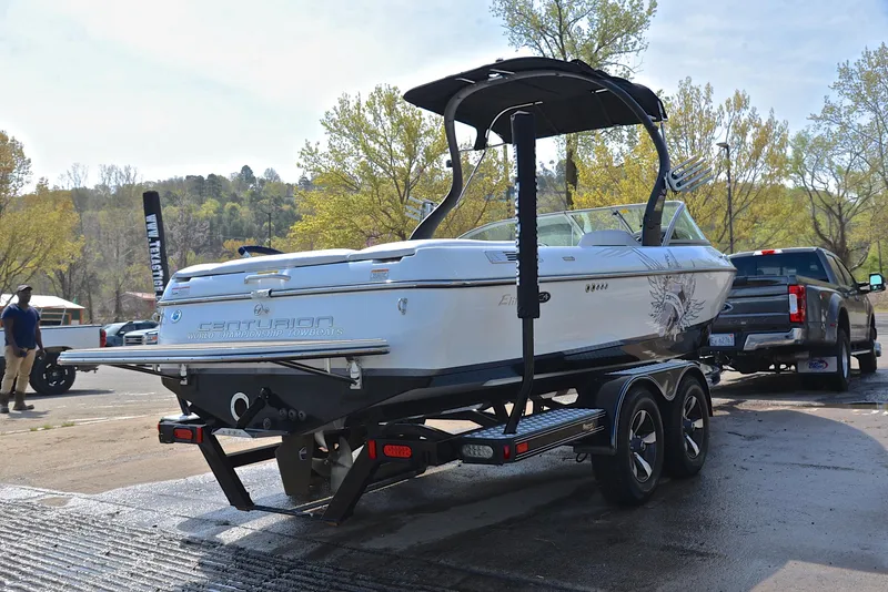 Slide: The Image of 2012 Centurion ELITE C4 boat on trailer, parked outdoors near trees. - 14