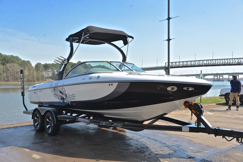 Slide: The Image of 2012 Centurion ELITE C4 boat on trailer by a lake, under clear sky. - 16