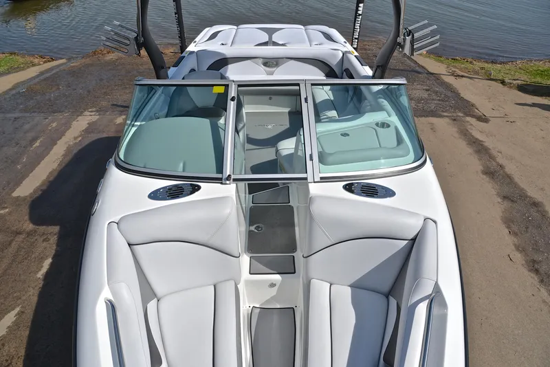 Slide: The Image of 2012 Centurion ELITE C4 boat with sleek white interior and windshield, docked by the water. - 20