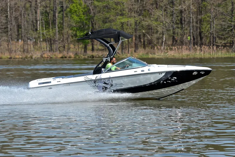 Slide: The Image of 2012 Centurion ELITE C4 speedboat cruising on a lake with forested background. - 3