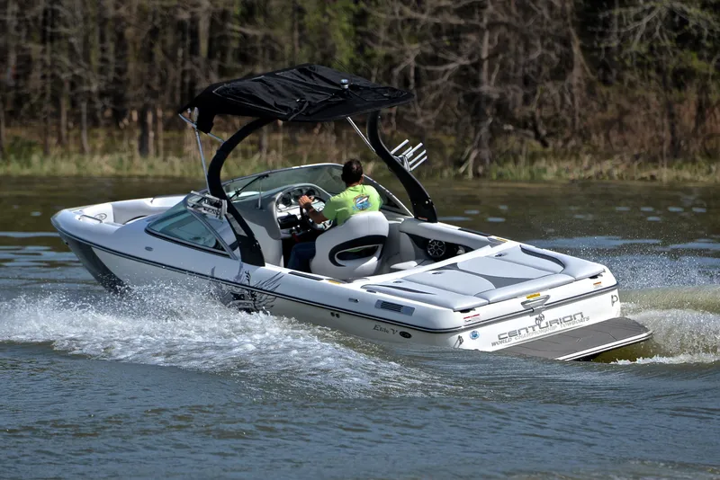 Slide: The Image of 2012 Centurion ELITE C4 boat cruising on a lake with a black canopy. - 6